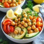 - 2 cans (15 oz each) chickpeas, drained and rinsed - 1 red bell pepper, diced into bite-sized pieces - 1 medium zucchini, sliced into half-moons - 1 red onion, cut into wedges - 1 cup cherry tomatoes, halved - 3 tablespoons extra-virgin olive oil - 1 teaspoon garlic powder - 1 teaspoon smoked paprika - 1 teaspoon dried oregano - Salt and freshly ground black pepper to taste The main ingredients form a colorful and healthy base. Chickpeas add protein, while the fresh vegetables bring crunch and flavor. The olive oil and spices enhance the dish, making each bite delightful. - 2 cups cooked quinoa or couscous (either works beautifully) Quinoa and couscous are great options for the base. Quinoa is nutty and full of protein. Couscous is light and fluffy. You can choose either based on your taste or what you have on hand. - Fresh parsley, chopped, for a vibrant garnish - Lemon wedges for a zesty finish Garnishing with fresh parsley adds color and freshness. Lemon wedges let you add a bright, tangy kick. This final touch elevates the dish and makes it even more enjoyable. 1. Preheat your oven to 400°F (200°C). 2. On a large baking sheet, combine the chickpeas, red bell pepper, zucchini, onion, and cherry tomatoes. This colorful mix will give your dish vibrancy. 1. Drizzle the mix with extra-virgin olive oil. Then, sprinkle garlic powder, smoked paprika, dried oregano, salt, and pepper on top. 2. Toss the ingredients with your hands or a spatula. Make sure everything is coated well. Spread the mixture evenly on the baking sheet for even roasting. 1. Cook your quinoa or couscous according to the package instructions. 2. After cooking, fluff it up with a fork for a light texture. This method ensures a tasty and easy meal. Enjoy each step as you create this delightful dish! To ensure even cooking, spread the chickpeas and veggies in a single layer. This helps them roast well without steaming. Stir the mixture halfway through cooking. This will encourage caramelization and prevent burning. Keep an eye on them; they should be golden brown and tender when done. For the best flavor, try adding cumin or coriander. These spices add warmth and depth. You can also mix in some feta cheese or olives for a salty kick. Want something spicy? Add a pinch of red pepper flakes. When assembling your bowls, start with a scoop of quinoa or couscous. Layer the roasted chickpeas and veggies on top. For a vibrant display, use wide bowls. Add a sprinkle of fresh parsley for color. Serve with lemon wedges on the side. A squeeze of lemon gives a zesty finish. {{image_4}} To make your Mediterranean chickpea bowls even heartier, you can add protein. For meat lovers, grilled chicken or shrimp works well. Simply season and cook them before adding to your bowls. If you prefer plant-based options, try adding tofu or tempeh. Both soak up flavors nicely and add texture. Feel free to swap in seasonal veggies. Bell peppers, zucchini, and cherry tomatoes are classic. However, you can also use asparagus, eggplant, or broccoli. All taste great when roasted. If you have extra veggies, you can freeze them. Just chop and store in bags. They will keep for a few months. While quinoa and couscous are great bases, other grains can work too. Try bulgur or farro for a different texture. If you need gluten-free options, consider rice or millet. Each grain adds its unique flavor, making your bowls fun and varied. Store your Mediterranean Chickpea Bowls in airtight containers. This keeps them fresh and prevents spills. They will last about 3-4 days in the fridge. If you notice any strange smells or colors, it’s time to toss them. To reheat in the oven, preheat to 350°F (175°C). Spread the mixture on a baking sheet. Heat for about 10-15 minutes until warm. Stir halfway through for even warmth. For the microwave, place the bowl in the microwave. Heat on high for 1-2 minutes. Check and stir to ensure even heat. Be careful, as the bowl can get hot. To freeze, let the bowls cool completely. Transfer the mixture into freezer-safe bags or containers. Remove as much air as possible. Label with the date. They will keep well for about 2-3 months. When you’re ready to enjoy, take them out and thaw overnight in the fridge. For a quicker option, run cold water over the sealed bag until thawed. Yes, this recipe is vegan! All the ingredients are plant-based. You use chickpeas, fresh veggies, and quinoa or couscous as a base. Just check the type of couscous if you choose it. Some brands offer different grains, so look for vegan options. You can also add more veggies or nuts for extra flavor and texture. This recipe is flexible and perfect for a vegan meal. You can change the spices to suit your taste. Try cumin for a warm flavor. If you like heat, add cayenne pepper or chili flakes. For a fresh note, use lemon zest. You can also mix in Italian herbs like basil or thyme. Experimenting with spices makes the dish exciting and personal. To get crispy chickpeas, follow these tips: - Dry well: Pat the chickpeas dry with a towel before cooking. - Space them out: Spread them evenly on the baking sheet. - Use enough oil: Drizzle enough olive oil to coat them lightly. - Stir halfway: Toss the mixture halfway through roasting so they crisp evenly. These steps will help you achieve that perfect crunch with every bite. This recipe blends chickpeas and fresh vegetables for a tasty meal. You learned how to prepare and roast them and add grains like quinoa or couscous as a base. I shared tips for flavor and presentation, plus some fun variations. You can store leftovers easily and enjoy them later. Explore all the options for your perfect dish, whether you're vegan or love protein. Cooking is about creativity, so have fun with your food. Enjoy bringing these flavors to your table!