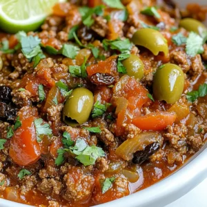 - 1 pound ground beef - 1 large onion, finely chopped - 1 green bell pepper, finely chopped - 2 cloves garlic, minced - 1 can (14 ounces) diced tomatoes, with juices - 2 tablespoons tomato paste - 1 tablespoon olive oil - 1 tablespoon apple cider vinegar - 1 cup pimento-stuffed green olives, sliced - 1/4 cup raisins - 1 teaspoon ground cumin - 1 teaspoon dried oregano - Salt and freshly ground black pepper, to taste - Fresh cilantro leaves for garnish (optional) When making Cuban Beef Picadillo, the right ingredients matter. Ground beef serves as the main protein. It gives the dish a hearty base. Fresh vegetables add flavor and texture. I use onion, green bell pepper, and garlic. These veggies create a savory aroma. Diced tomatoes and tomato paste bring richness. They add both moisture and flavor to the dish. Olive oil is essential for cooking. It helps saut&eacute; the vegetables and adds a nice taste. Apple cider vinegar provides a tangy kick and balances the dish's sweetness. Herbs and spices are vital. Ground cumin and dried oregano bring warmth and depth. For a unique twist, I add pimento-stuffed green olives. They give a salty bite. Raisins balance this with a touch of sweetness. This combo creates a dish full of flavor. Each ingredient plays a role in making Cuban Beef Picadillo special. Choose fresh and high-quality items for the best result. {{ingredient_image_2}} - Heat 1 tablespoon of olive oil in a large skillet over medium heat. - Add 1 large onion and 1 green bell pepper, both finely chopped. - Saut&eacute; for about 5 minutes until the onion is soft and clear. - Then, add 2 cloves of minced garlic and stir for 1 minute. The garlic should smell great. - Raise the heat to medium-high and add 1 pound of ground beef. - Use a spatula to break the meat into small pieces. - Brown the beef for 6 to 8 minutes, stirring often. - If there&rsquo;s too much fat, drain it out carefully. - Next, stir in 1 can of diced tomatoes, 2 tablespoons of tomato paste, and 1 tablespoon of apple cider vinegar. - Add 1 teaspoon of ground cumin and 1 teaspoon of dried oregano. Mix well. - Now, add 1 cup of sliced pimento-stuffed green olives and 1/4 cup of raisins. - Stir until everything is evenly mixed. - Season with salt and freshly ground black pepper to taste. - Reduce the heat and let it simmer for 15 to 20 minutes. - Stir occasionally to keep it from sticking. - When finished, taste and adjust the seasoning as needed. To get that true Cuban taste, start with quality beef. Use fresh ground beef for the best flavor. Fresh ingredients make a big difference too. Choose ripe tomatoes and bright bell peppers. The right balance of sweetness and acidity is key. The raisins add sweetness, while the vinegar brings a tang that brightens the dish. Simmering is crucial for depth of flavor. Let the picadillo cook slowly. This helps the flavors mix well. A good simmer takes about 15 to 20 minutes. Stirring is also important. It helps cook the beef evenly and prevents sticking. When serving Cuban Beef Picadillo, pair it with fluffy white rice. Black beans are a classic side that complements the dish. You can also serve it with crispy fried plantains. For a pop of color, garnish with fresh cilantro leaves. A lime wedge on the side adds a zesty touch. Pro Tips Use Lean Ground Beef: Opt for 80/20 or leaner ground beef to reduce excess fat while still enjoying flavorful meat. Enhance with Spices: Feel free to add a pinch of cayenne pepper or smoked paprika for an extra layer of flavor and a hint of spice. Let it Rest: Allow the picadillo to rest for a few minutes after cooking; this helps the flavors meld together for a more delicious dish. Pair with Fresh Sides: Complement the picadillo with fresh avocado slices or a simple green salad to balance the richness of the dish. {{image_4}} You can swap ground beef for other meats. Ground turkey or chicken works well. They will keep the dish light but still tasty. If you want a vegetarian option, try lentils or mushrooms. They both add a nice texture and flavor. To add depth, consider using spices. Bay leaves and paprika are great choices. They will boost the aroma and taste. You can also add more vegetables. Chopped carrots blend well and add sweetness. There are fun ways to serve picadillo. You can fill tacos with it for a hand-held meal. Another option is to serve it over polenta for a hearty dish. You could also create a Cuban-style bowl. Just add rice and beans for a complete meal. To keep your Cuban Beef Picadillo fresh, use airtight containers. Glass or plastic containers work well. Store it in the fridge for up to four days. Make sure it cools down before sealing. This helps keep the flavors strong and safe to eat. You can freeze Cuban Beef Picadillo for later use. Let it cool completely first. Then, place it in a freezer-safe container or bag. Make sure to push out any air to avoid freezer burn. It can last for up to three months in the freezer. When ready to enjoy, thaw it overnight in the fridge for best flavor. To reheat, use the stove or microwave. If using the stove, heat it in a skillet over low heat. Stir often to keep it from sticking. If you prefer the microwave, place it in a bowl and cover. Heat it in 30-second intervals, stirring in between. The ideal serving temperature is around 165&deg;F. This ensures it's hot and tasty. Cuban Beef Picadillo is a savory dish made with ground beef. It has roots in Cuba and blends Spanish, African, and Caribbean flavors. This dish is comforting and packed with spices. It often includes olives and raisins, giving it a unique taste. Cuban families enjoy picadillo for special occasions and everyday meals. Each bite tells a story of rich culture and tradition. Yes, you can make Cuban Beef Picadillo ahead of time! It stores well in the fridge for up to three days. To do this, let the dish cool, then place it in an airtight container. For longer storage, you can freeze it. Just make sure to use a freezer-safe container. When ready to eat, thaw it overnight in the fridge. Reheat gently on the stove to keep the flavors fresh. Cuban Beef Picadillo pairs well with many sides. Here are some popular options: - Fluffy white rice - Black beans - Crispy fried plantains - A simple green salad - Avocado slices You can also serve it with lime wedges for a zesty twist. Each side enhances the dish&rsquo;s flavor and makes your meal even more delightful. Enjoy your Cuban feast! Cuban Beef Picadillo offers a tasty mix of ground beef, veggies, and spices. You learned about essential ingredients, step-by-step cooking, and tips for the best flavor. Remember to adjust flavors for your taste and try different proteins if needed. Storing properly keeps leftovers fresh. Exploring this dish pays off with rich meals or simple snacks. Enjoy bringing this Cuban classic to your kitchen and sharing it with loved ones.