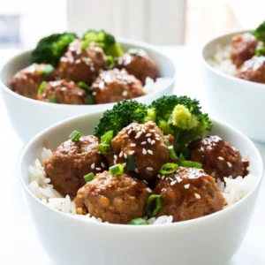 To make the meatballs, you need: - 1 lb ground chicken or turkey - 1/2 cup breadcrumbs - 1/4 cup grated Parmesan cheese - 1 large egg - 2 green onions, finely chopped - 2 cloves garlic, minced - 1 tsp fresh ginger, minced - Salt and black pepper to taste These ingredients create a tasty and moist base for your meatballs. Ground chicken or turkey keeps them light. The breadcrumbs and cheese add texture and flavor. The egg helps bind everything together. Green onions, garlic, and ginger provide a fresh kick. For the teriyaki sauce, you will need: - 1/4 cup soy sauce - 1/4 cup honey - 2 tbsp rice vinegar - 1 tbsp sesame oil This sauce brings a sweet and salty flavor. The soy sauce gives depth, while honey adds sweetness. Rice vinegar adds a nice tang, and sesame oil provides a nutty finish. Together, they coat the meatballs perfectly. For serving, gather: - 1 cup cooked jasmine rice - 1 cup steamed broccoli florets - Sesame seeds for garnish - Additional chopped green onions for garnish (optional) Cooked jasmine rice makes a soft base for the bowls. Broccoli adds color and crunch. Sesame seeds and green onions give a nice touch on top. This combination makes your meal balanced and appealing. {{ingredient_image_2}} 1. Preheat the Oven: Heat the oven to 400&deg;F (200&deg;C). This step is key for crispy meatballs. 2. Mix Ingredients: In a large bowl, add 1 pound of ground chicken or turkey. Then, add 1/2 cup of breadcrumbs, 1/4 cup of grated Parmesan cheese, and 1 large egg. Toss in 2 finely chopped green onions, 2 cloves of minced garlic, and 1 teaspoon of minced ginger. Season with salt and black pepper to your taste. Mix gently with your hands or a spoon until combined. Avoid overmixing to keep the meatballs tender. 3. Shape the Meatballs: Roll the mixture into balls about 1 inch in size. Place them on a lined baking sheet. 4. Bake the Meatballs: Insert the baking sheet into the preheated oven. Bake for 15-20 minutes. Check that the meatballs reach an internal temperature of 165&deg;F (75&deg;C) and turn golden brown. 5. Make the Teriyaki Sauce: While the meatballs bake, prepare the sauce. In a small saucepan over medium heat, combine 1/4 cup of soy sauce, 1/4 cup of honey, 2 tablespoons of rice vinegar, and 1 tablespoon of sesame oil. Stir until the honey melts. Simmer for 2-3 minutes, then remove from heat. 6. Coat the Meatballs: Once cooked, drizzle the teriyaki sauce over the meatballs. Toss gently to coat each meatball with sauce. 7. Assemble Your Bowls: Start with a base of 1 cup of cooked jasmine rice in each bowl. Add 1 cup of steamed broccoli florets. Finally, place the coated meatballs on top. 8. Garnish and Serve: Sprinkle sesame seeds over the meatballs for crunch. Optionally, add more chopped green onions for color. Enjoy your delicious teriyaki meatball bowls! - Use fresh ingredients. Fresh garlic and ginger add great flavor. - Don&rsquo;t overmix your meatball mixture. This keeps them tender. - Wet your hands when shaping meatballs. It helps prevent sticking. - Space meatballs evenly on the baking sheet. This ensures even cooking. - Check the internal temperature. Meatballs should reach 165&deg;F (75&deg;C) for safety. - Try adding spices like garlic powder or onion powder for extra flavor. - Mix in chopped herbs like cilantro or basil for freshness. - Use low-sodium soy sauce if you prefer less salt. - Drizzle a bit of sesame oil over the finished dish for a nutty flavor. - Let the teriyaki sauce simmer longer for a thicker, richer taste. - Serve over jasmine rice for a classic touch. - Add steamed vegetables like broccoli or snap peas for color and nutrition. - Garnish with sesame seeds and green onions for crunch and flair. - Offer lime wedges on the side for a zesty kick. - Pair with a light salad for a fresh contrast to the meatballs. Pro Tips Use Panko Breadcrumbs: For an extra crispy texture, substitute regular breadcrumbs with panko breadcrumbs in your meatball mixture. Let the Meatballs Rest: After baking, allow the meatballs to rest for a few minutes before serving. This helps them retain moisture and improves flavor. Customize Your Sauce: Feel free to adjust the ratio of soy sauce and honey to achieve your desired balance of savory and sweet in the teriyaki sauce. Mix in Veggies: Enhance the nutrition of your meatballs by adding finely chopped vegetables like carrots or bell peppers to the meat mixture. {{image_4}} You can easily make this dish vegetarian or vegan. Use plant-based ground meat instead of chicken or turkey. Options like lentils or chickpeas work well. Make your meatballs by mashing these beans with breadcrumbs and spices. Use flaxseed mixed with water instead of an egg to bind the mixture. For the teriyaki sauce, check that your soy sauce is vegan-friendly, or use tamari for a gluten-free version. To make this dish gluten-free, swap regular soy sauce for tamari. You can also use gluten-free breadcrumbs in the meatballs. Jasmine rice is naturally gluten-free, but always check labels. This way, you can enjoy delicious teriyaki meatball bowls without worry. Feel free to get creative with your ingredients! If you want a spicier kick, add sriracha or chili flakes to the teriyaki sauce. You can also use different meats, like beef or pork, for your meatballs. Try adding fresh herbs like cilantro or basil for extra flavor. Experiment with other veggies like bell peppers or snap peas to make your bowl even more colorful and tasty. To store your teriyaki meatball bowls, let them cool first. Once cool, put them in an airtight container. You can keep them in the fridge for up to three days. This way, you can enjoy your tasty meal later without losing flavor. When you want to eat the leftovers, you can reheat them easily. Place the meatballs and rice in a microwave-safe bowl. Cover the bowl with a damp paper towel to keep moisture in. Heat for about two minutes or until warm. Stir halfway through to ensure even heating. You can also reheat them on a stovetop over low heat, stirring gently until hot. If you want to save your teriyaki meatball bowls for longer, freezing is a great option. Place the cooled meatballs and rice in separate freezer-safe bags. Remove as much air as possible before sealing. They can last up to three months in the freezer. To thaw, move the bags to the fridge for several hours or overnight. If you&rsquo;re in a hurry, you can use the microwave's defrost setting. Once thawed, reheat as described above. Enjoy your delicious meal anytime! To make teriyaki sauce, you need a few simple ingredients. Mix together 1/4 cup soy sauce, 1/4 cup honey, 2 tablespoons rice vinegar, and 1 tablespoon sesame oil. Heat this mix in a small pot over medium heat. Stir until the honey mixes well into the sauce. Let it simmer for 2-3 minutes to thicken it slightly. This sauce adds a sweet and savory flavor to your meatballs. Yes, you can use different types of meat. Ground beef or pork works well. If you want a lighter option, ground turkey or chicken is great too. Each meat gives a unique taste and texture. Just remember to adjust your cooking times as needed. The key is to make sure the meatballs are cooked through, reaching an internal temperature of 165&deg;F (75&deg;C). Teriyaki meatball bowls are great with a variety of sides. I love serving them over steamed jasmine rice. You can also add veggies like steamed broccoli or bell peppers for color and crunch. If you want to go the extra mile, add a side of edamame or pickled ginger. These sides complement the sweet and savory flavors of the meatballs perfectly. These teriyaki meatballs are simple and fun to make. You need key ingredients for both meatballs and sauce. Follow the steps for prep, cooking, and assembly to enjoy a tasty dish. Use tips to enhance flavors and make meal variations that fit your diet. Store leftovers properly for later. By answering common questions, I hope I helped you feel ready to cook. Enjoy your meal!